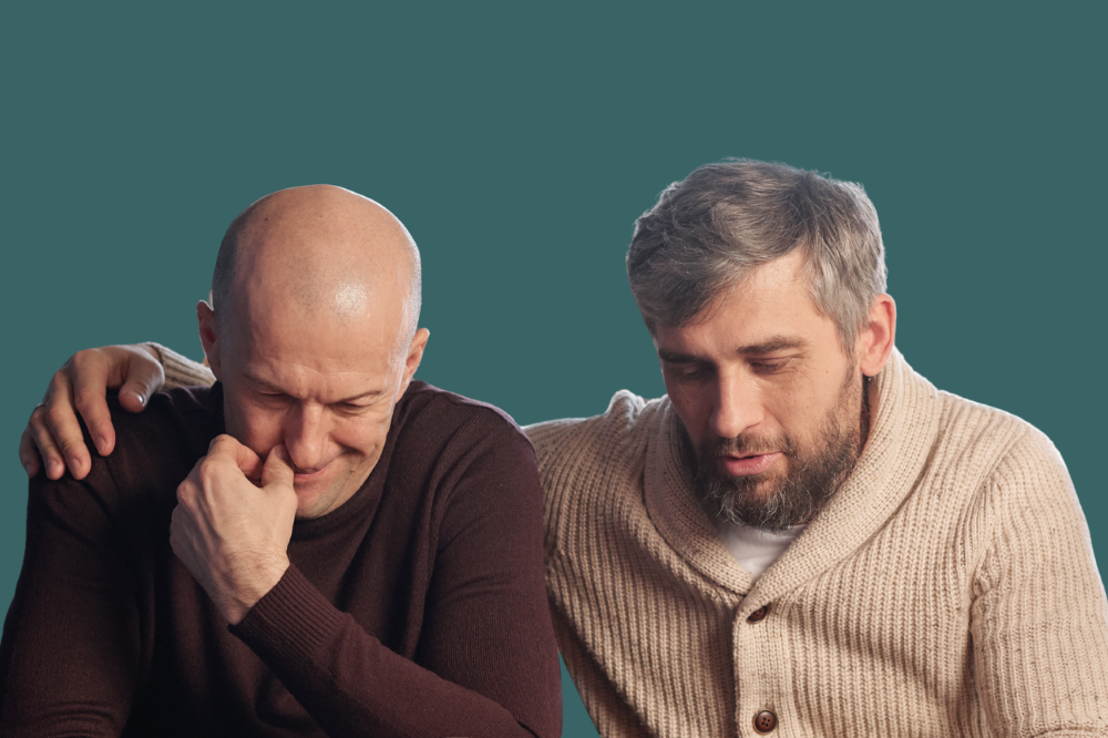 Ein mann med handa på skuldera til ein annan mann