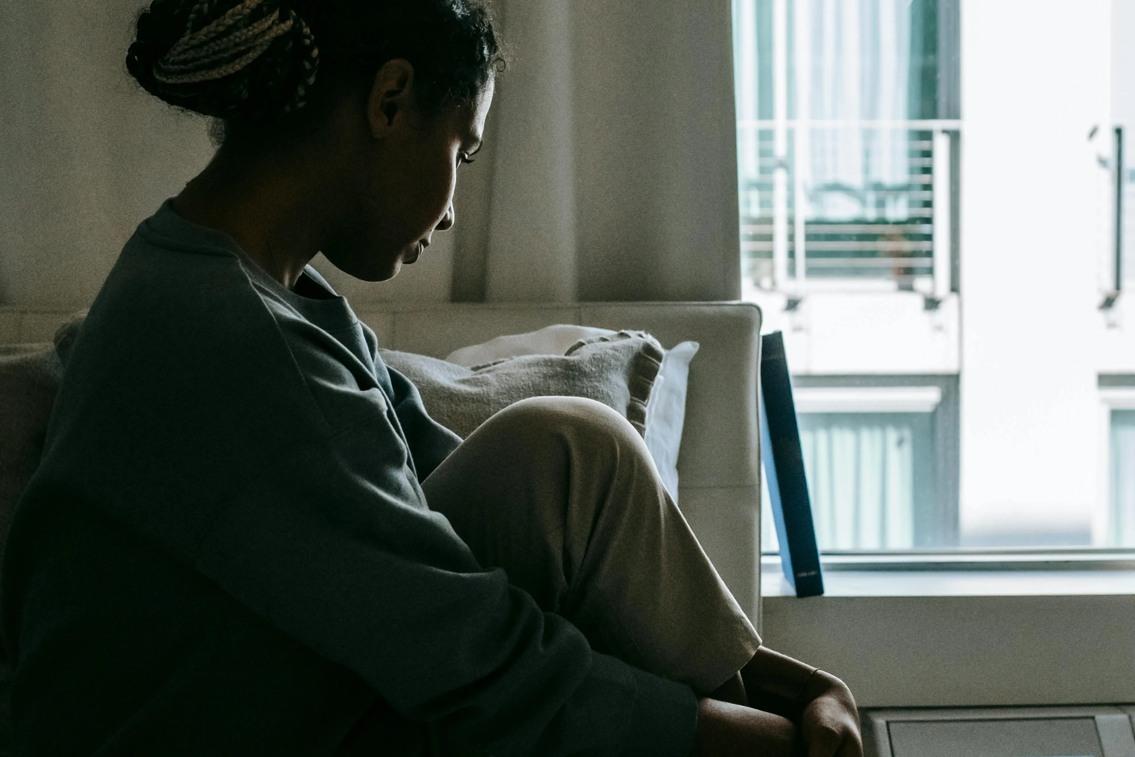 Ei kvinne i profil, som sit i ein stol