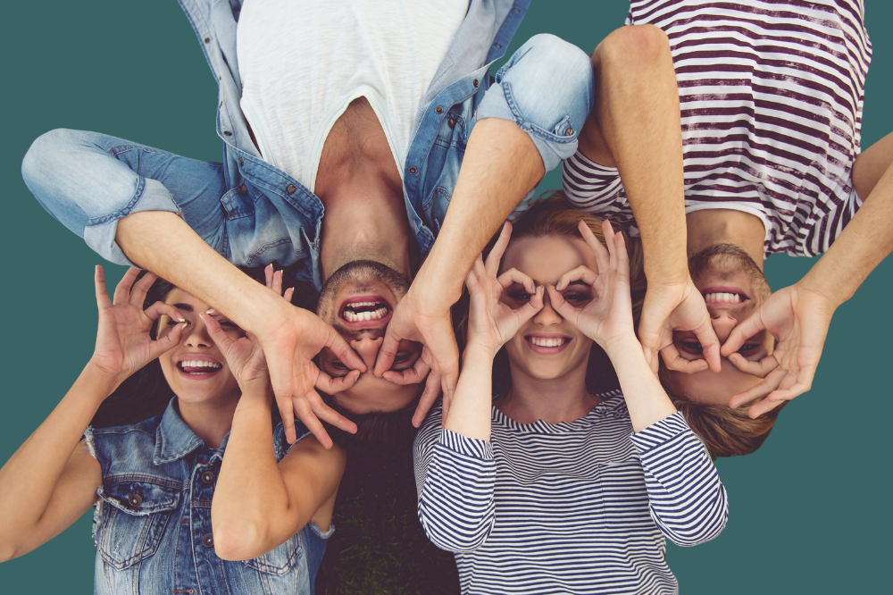 Ei gruppe ungdomar med hendene som lagar ein kikkert framfor augo