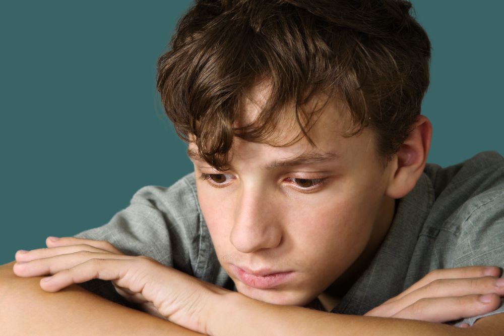 Ein tenksam gut med hovudet støtta på hendene