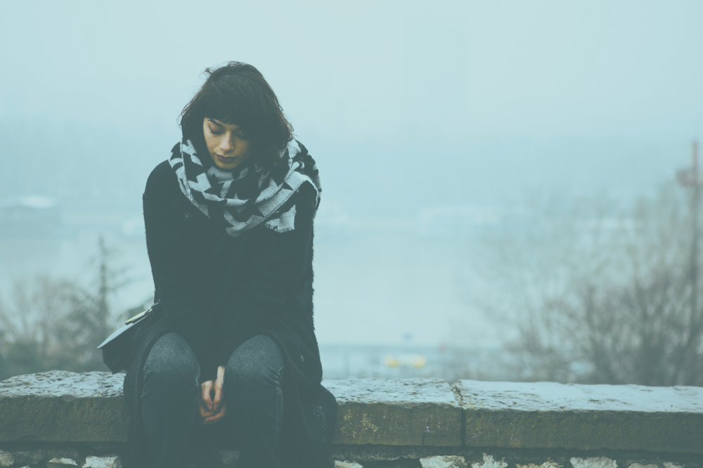 Ein person som sit på ein avsats.