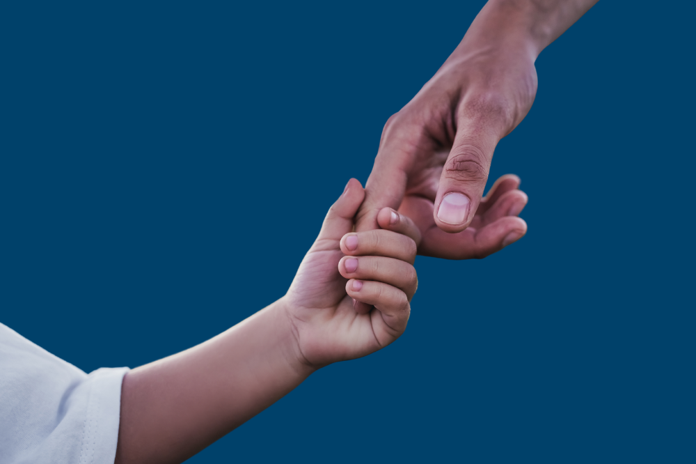 Eit nærbilete av hendene til eit barn og ein vaksen som held saman.