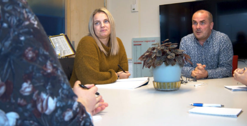 Ei gruppe menneske som sit ved eit bord.