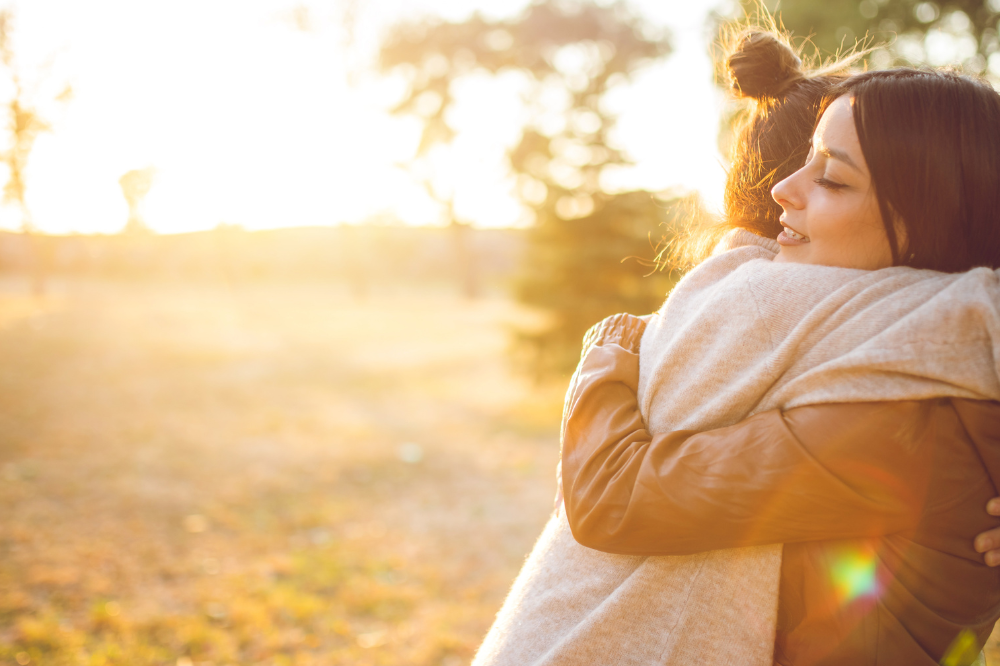 To kvinner som klemmer kvarandre.