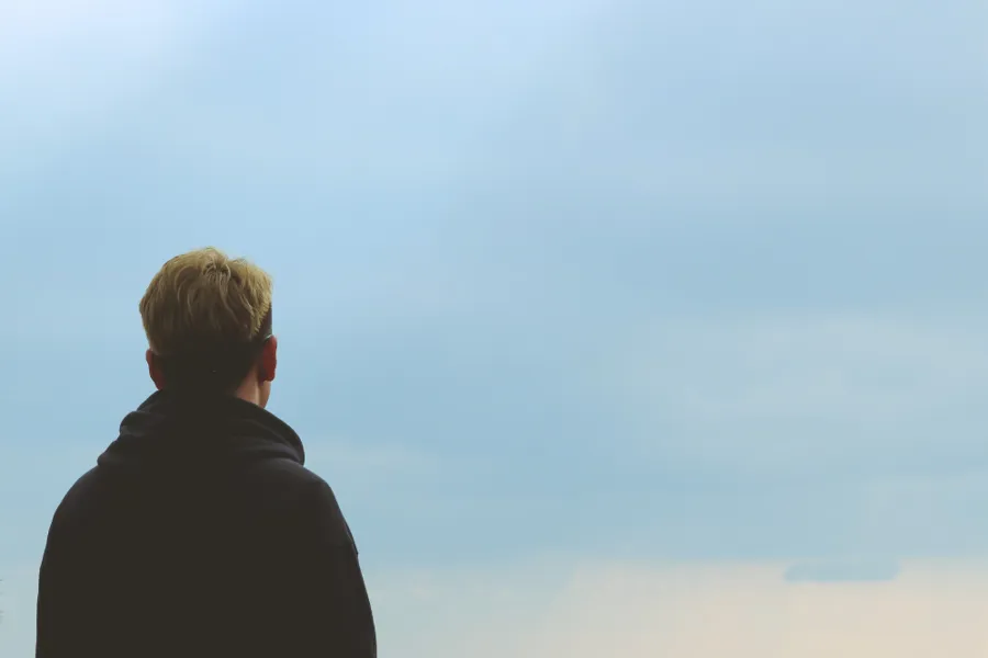Baksida av ein person som ser på himmelen