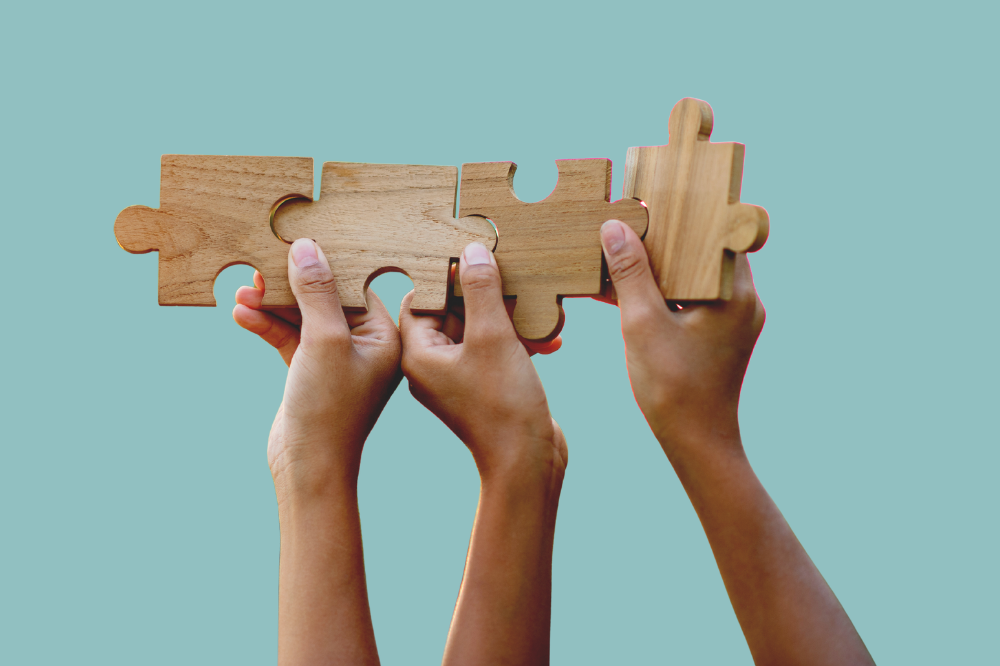 Et par hender som held puslespelbitar i tre