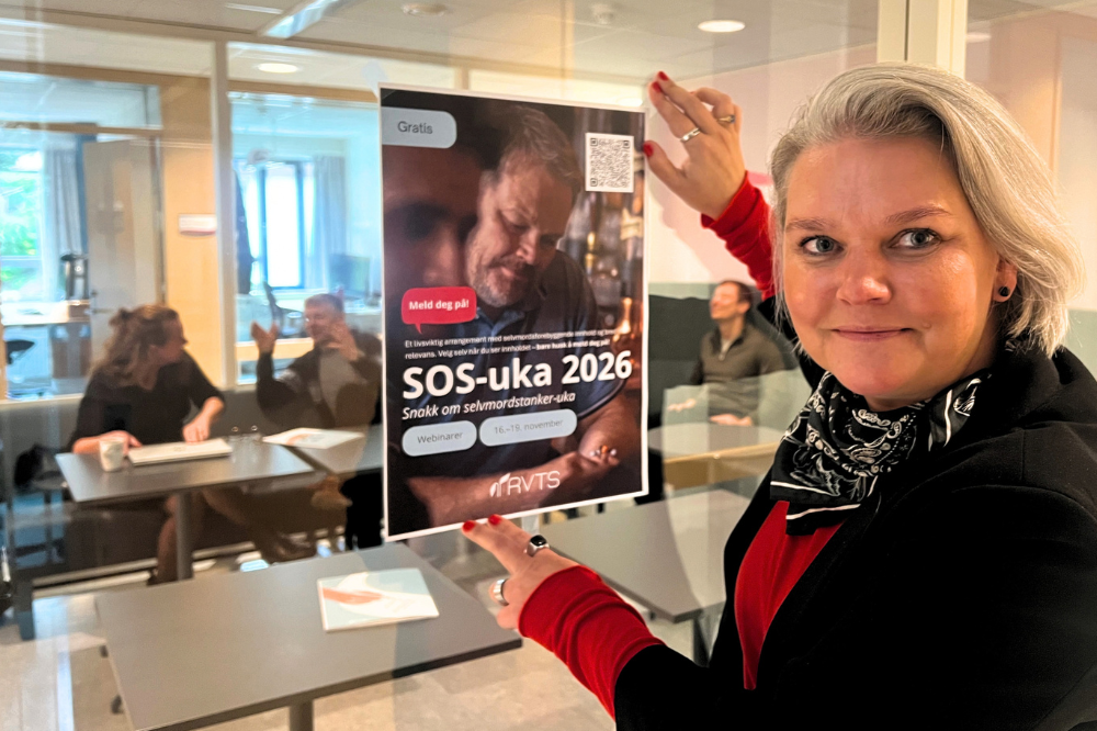 Linda Thomassen som viser plakaten for SOS-uka