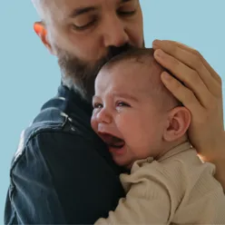 Ein mann som trøster ein baby